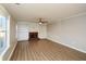 Bright living room featuring a brick fireplace with built-in bookshelves, hardwood flooring, and a modern ceiling fan at 3820 Mast Nw Ct, Kennesaw, GA 30144