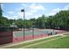 A tennis court is surrounded by a black fence and trees, providing a serene and private playing experience at 3820 Mast Nw Ct, Kennesaw, GA 30144