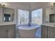 Luxurious bathroom with freestanding tub, double vanity, and large windows at 1005 Middlebrooke Dr, Canton, GA 30115