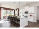 Modern kitchen featuring white cabinets, an island with seating, and a view of the dining area at 128 Kingsley Way, Acworth, GA 30102