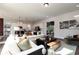 Bright living room featuring white sofas and a view into the modern, eat-in kitchen at 128 Kingsley Way, Acworth, GA 30102