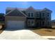 Charming two-story home with brick and siding, attached garage, and a well-manicured lawn at 446 Rodeo Dr, Auburn, GA 30011