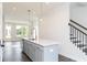 Stylish kitchen island with pendant lighting and a view of the dining area and staircase at 353 Skylar Se Way, Atlanta, GA 30315