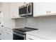 Close up of the kitchen featuring a stainless steel microwave, range, and sleek backsplash at 353 Skylar Se Way, Atlanta, GA 30315