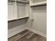 Walk in closet features custom shelving with black rods and wood-look floors at 4035 Hosch Retreat Dr, Buford, GA 30519