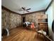 Spacious bedroom with hardwood floors, ceiling fan, and rustic wood-paneled walls at 5121 Newark Ave, Clarkdale, GA 30111