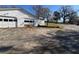 Angle view of detached garage with large parking pad and a sunny sky at 5121 Newark Ave, Clarkdale, GA 30111