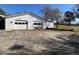 View of detached two-bay garage with large parking pad and sunny sky at 5121 Newark Ave, Clarkdale, GA 30111