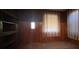 Cozy living room with wooden paneling, a ceiling fan, and bright windows for natural light at 5121 Newark Ave, Clarkdale, GA 30111