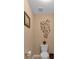 Small powder room with toilet and decorative wall art at 4504 Sterling Pointe Nw Dr, Kennesaw, GA 30152