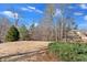 View of the backyard with a large, open grassy area, mature trees, and partial fencing at 416 Telfair Way, Canton, GA 30115