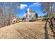 View of the backyard with a sloped lot and a charming two-story home with neutral siding at 416 Telfair Way, Canton, GA 30115