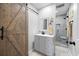 Bathroom featuring a gray vanity and a glass-enclosed shower with gray stone tile and a barn door at 416 Telfair Way, Canton, GA 30115