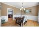 Traditional dining room featuring hardwood floors, wainscoting, and elegant chandelier at 416 Telfair Way, Canton, GA 30115