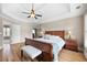 Bedroom featuring a wood bed, tray ceiling, hardwood flooring, and ensuite access, creating a luxurious retreat at 416 Telfair Way, Canton, GA 30115