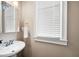 Bright powder room with a white sink, decorative mirror, and a window with natural light at 416 Telfair Way, Canton, GA 30115