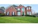 Brick two-story house with a large front yard and landscaping at 4740 Eagles Ridge Loop, Stonecrest, GA 30038