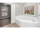 Bathroom with corner soaking tub and tile flooring at 730 Pinehurst Dr, Fairburn, GA 30213