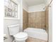 Clean bathroom with a bathtub, toilet and brown tile at 730 Pinehurst Dr, Fairburn, GA 30213