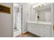 Bathroom vanity with white cabinets, mirror, and a view of the shower at 1109 Wiley Bridge Rd, Woodstock, GA 30188