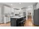 Well-appointed kitchen featuring an island with seating, white cabinets, and hardwood floors at 1109 Wiley Bridge Rd, Woodstock, GA 30188