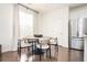 Modern dining area with a round wooden table and six beige chairs at 875 Venture Sw Way, Atlanta, GA 30331