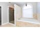 Bright bathroom featuring a soaking tub, walk-in shower, and decorative stone accents at 116 Big Cotton Trl, Mcdonough, GA 30252