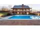 Stunning backyard with large in-ground pool, deck, and two story brick home with balconies at 116 Big Cotton Trl, Mcdonough, GA 30252