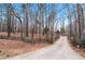 Long driveway leading to a home surrounded by trees at 3355 Old Peachtree Rd, Dacula, GA 30019