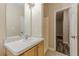 Bathroom featuring a vanity with wood cabinetry, mirror, and an open doorway at 4671 W Lake Se Dr, Conyers, GA 30094