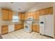 Bright kitchen with white appliances, wood cabinets, granite countertops and tile floors at 4671 W Lake Se Dr, Conyers, GA 30094