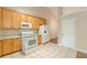Kitchen featuring wood cabinets, white appliances, granite countertops and tile floors at 4671 W Lake Se Dr, Conyers, GA 30094