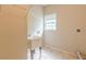 Bright laundry room features a utility sink, storage shelf, and window at 4671 W Lake Se Dr, Conyers, GA 30094