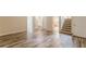 Open-concept living room featuring laminate flooring, stairs to the upper level, and doorways to other rooms at 4671 W Lake Se Dr, Conyers, GA 30094