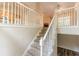 Carpeted staircase with white banister leading to the upper level and kitchen at 4671 W Lake Se Dr, Conyers, GA 30094