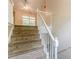 Carpeted staircase with white banister leading to the upper level at 4671 W Lake Se Dr, Conyers, GA 30094