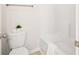 Bathroom including a toilet, and a tub with white tiled surround at 7710 Tiberon Pkwy, Cumming, GA 30028