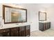 Spacious bathroom with dual vanities, dark wood cabinets, and framed mirrors at 7710 Tiberon Pkwy, Cumming, GA 30028