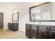 Well-lit bathroom with dual vanities, dark wood cabinets, and framed mirrors at 7710 Tiberon Pkwy, Cumming, GA 30028
