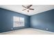 Cozy bedroom featuring a ceiling fan and a window providing natural light and blue painted walls at 7710 Tiberon Pkwy, Cumming, GA 30028