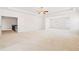 Spacious bedroom with neutral carpet, tray ceiling with fan, and windows with views of the outdoors at 7710 Tiberon Pkwy, Cumming, GA 30028