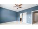 Bedroom with blue walls, carpet, ceiling fan, and doors to other rooms at 7710 Tiberon Pkwy, Cumming, GA 30028