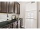 Butler's pantry boasts dark cabinets, sleek black counters, and stylish subway tile backsplash at 7710 Tiberon Pkwy, Cumming, GA 30028