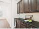 Butler's pantry has dark cabinets, black counters, white subway tile backsplash, and is ready for entertaining at 7710 Tiberon Pkwy, Cumming, GA 30028