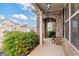 Inviting front porch with stone archway, black door, and decorative details at 7710 Tiberon Pkwy, Cumming, GA 30028