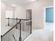 Hallway with wooden banister and open doors to bedrooms at 7710 Tiberon Pkwy, Cumming, GA 30028