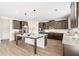 Spacious kitchen features an island, stainless steel appliances, and dark wood cabinetry at 7710 Tiberon Pkwy, Cumming, GA 30028