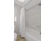 Bathroom featuring a combination shower and bathtub with marble tile and a window at 96 Grand Ave, Suwanee, GA 30024