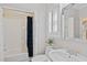 Bathroom featuring white fixtures, a walk-in shower, and natural light, with a view of the staircase at 96 Grand Ave, Suwanee, GA 30024
