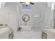 Bright bathroom boasts a standalone tub, glass shower, and double vanity with granite countertops at 96 Grand Ave, Suwanee, GA 30024